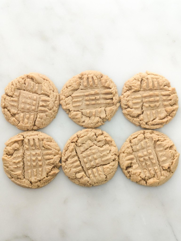 Six peanut butter cookies arranged on marble