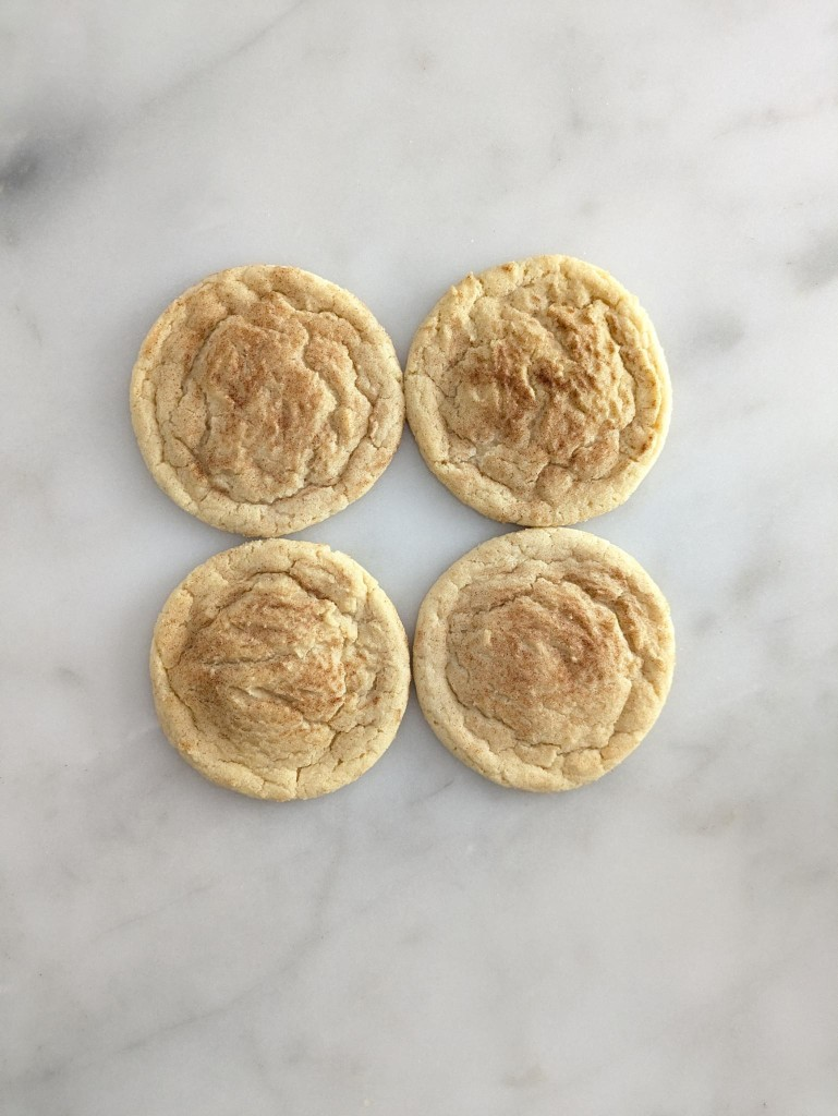 Four snickerdoodle cookies arranged on marble